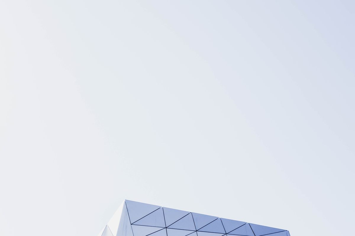 A modern building facade of repeating geometric panels against an open sky — an illustrative image for structure and considered design.