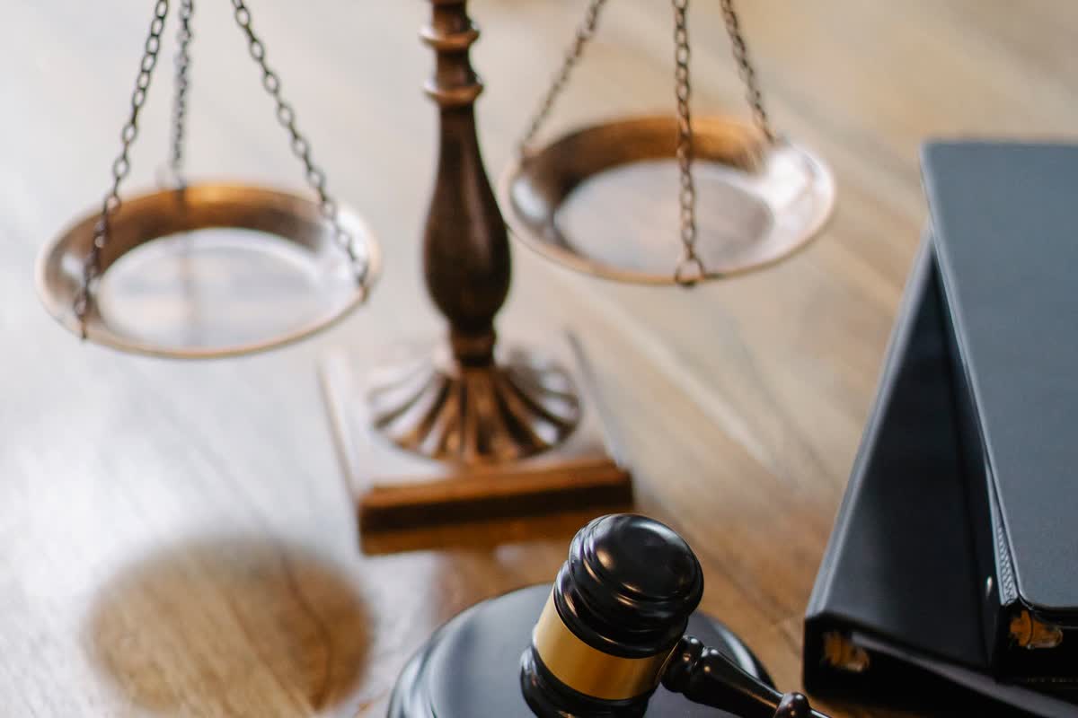 A gavel and scales of justice on a desk: an illustrative image for governance and compliance.