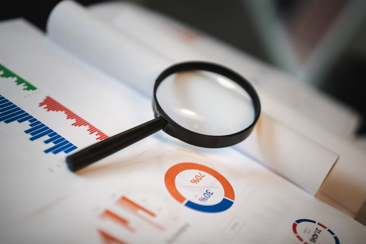 A magnifying glass over financial charts: an illustrative image for evaluating a consultant's claims.