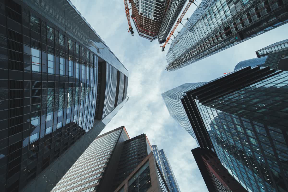 An upward view of towering contemporary skyscrapers: an illustrative image for compounding growth.