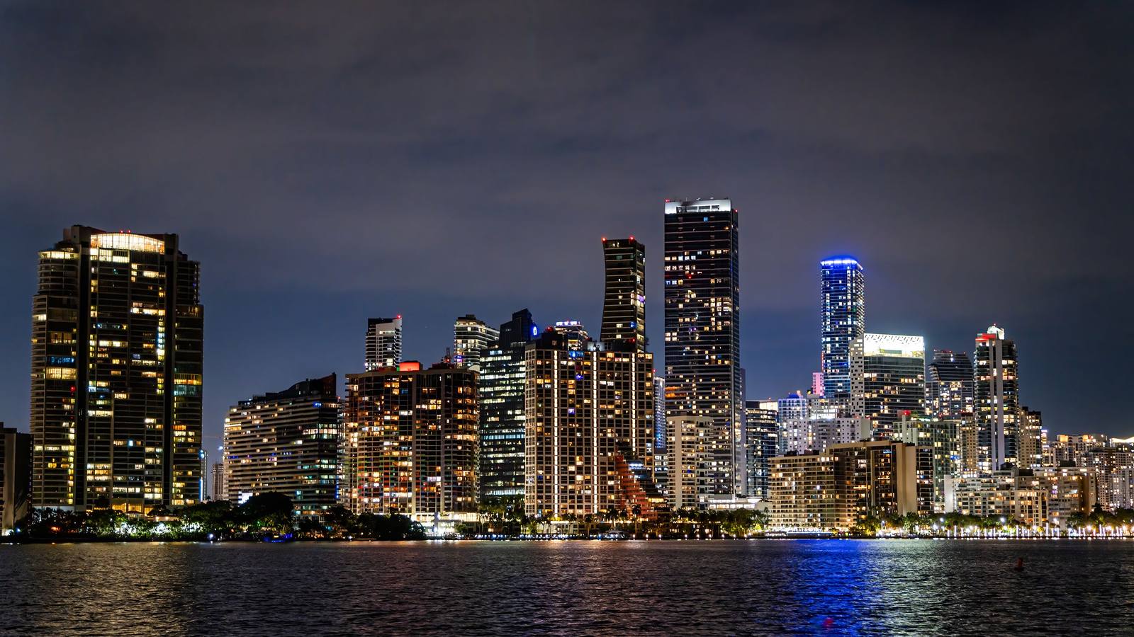 The Brickell and downtown Miami skyline lit at night across Biscayne Bay, illustrative of the Miami area.