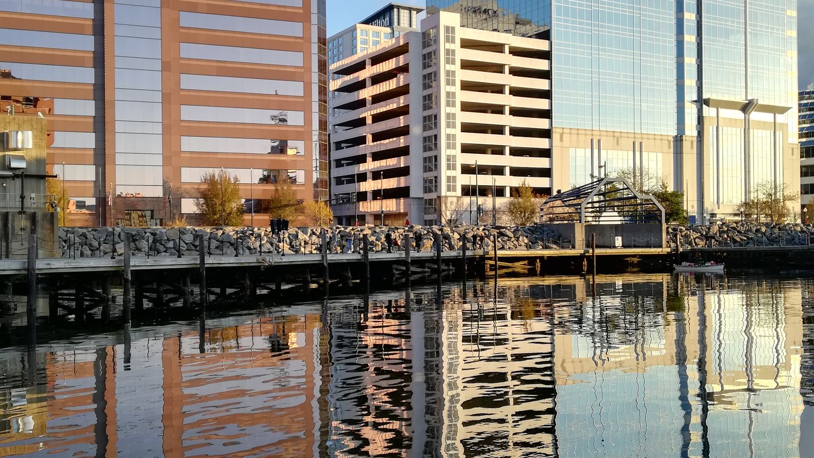 Downtown Norfolk towers reflected in calm harbor water, an illustrative image for the firm's Norfolk service area.