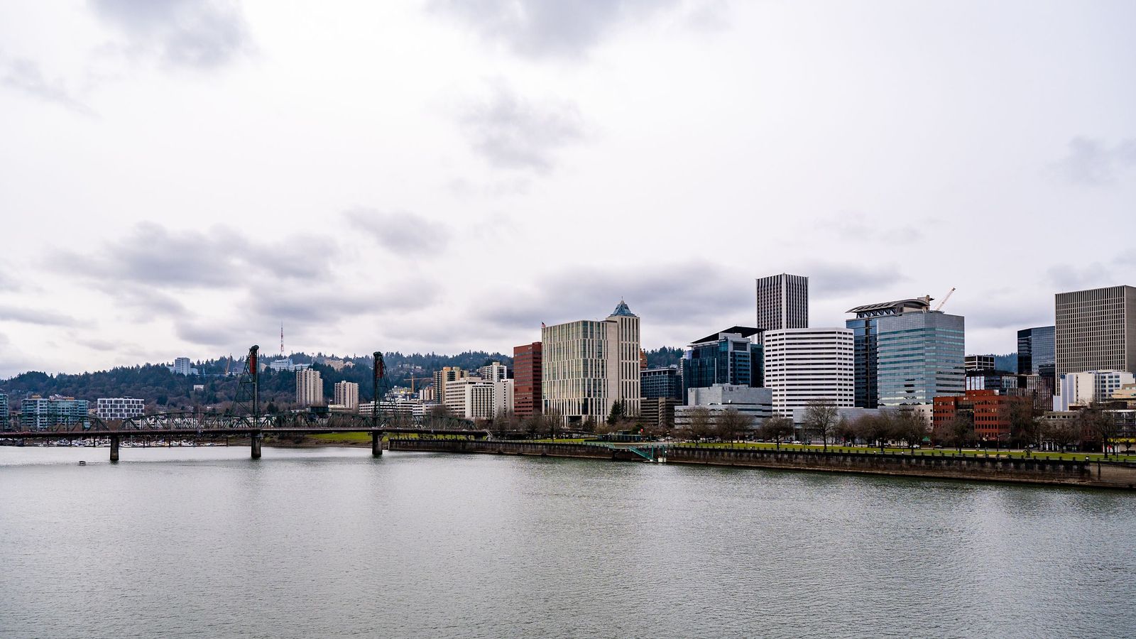 Downtown Portland and the Hawthorne Bridge on the Willamette River under an overcast sky, illustrative of the Portland area.