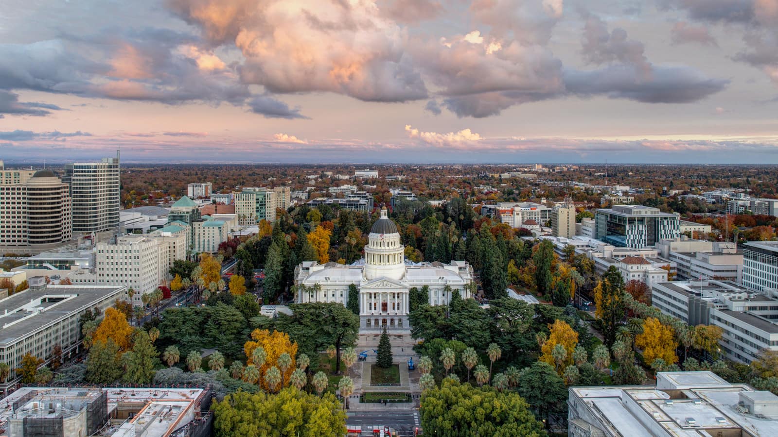 The California State Capitol and its tree-lined park from the air at sunset, an illustrative image for the firm's Sacramento service area.