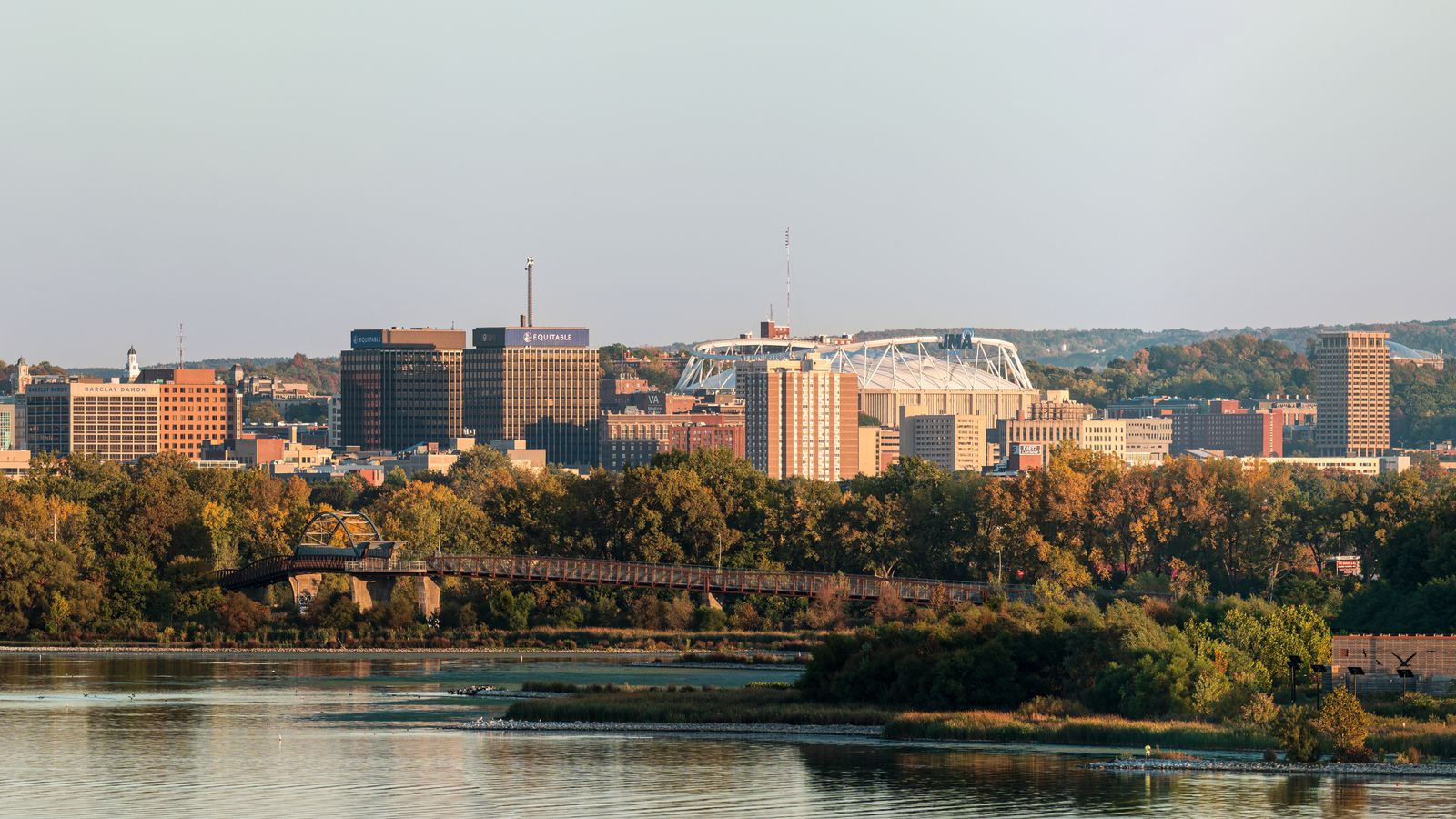 The Syracuse skyline and stadium roof seen across Onondaga Lake in autumn, an illustrative image for the firm's Syracuse service area.