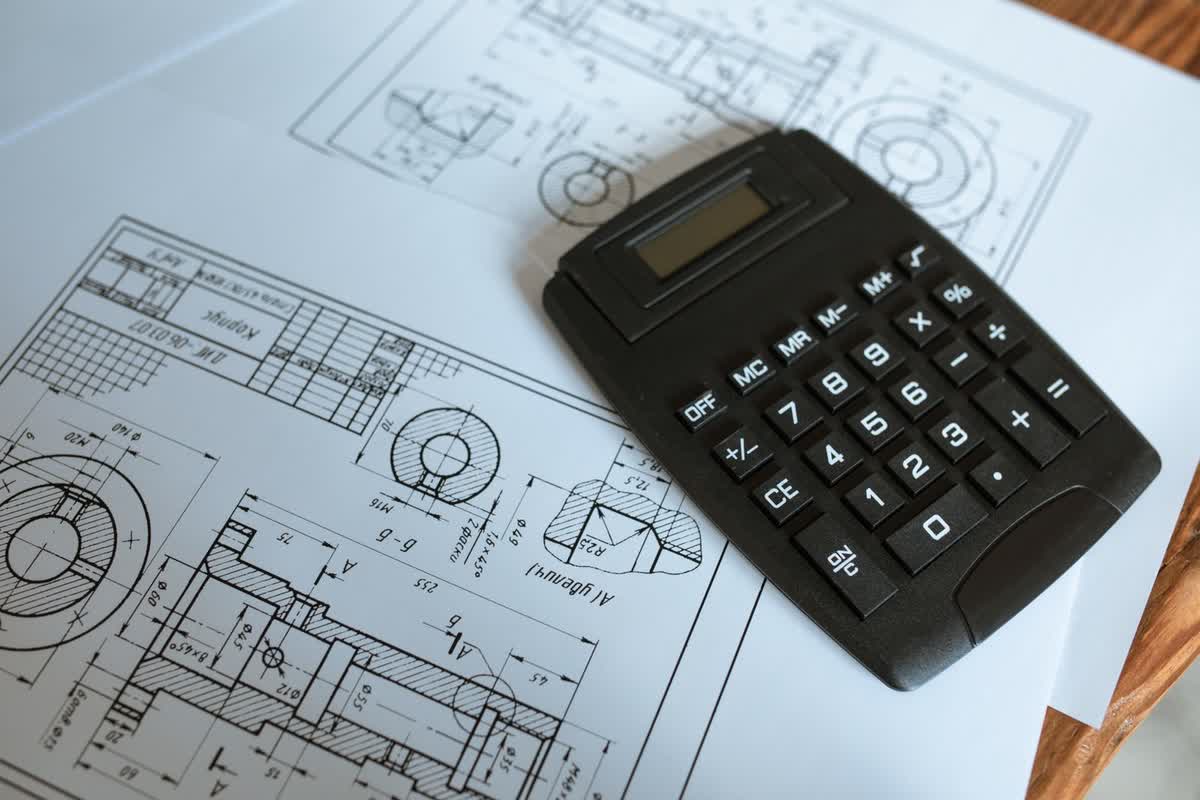 A calculator resting on architectural blueprints: an illustrative image for pricing and scoping.