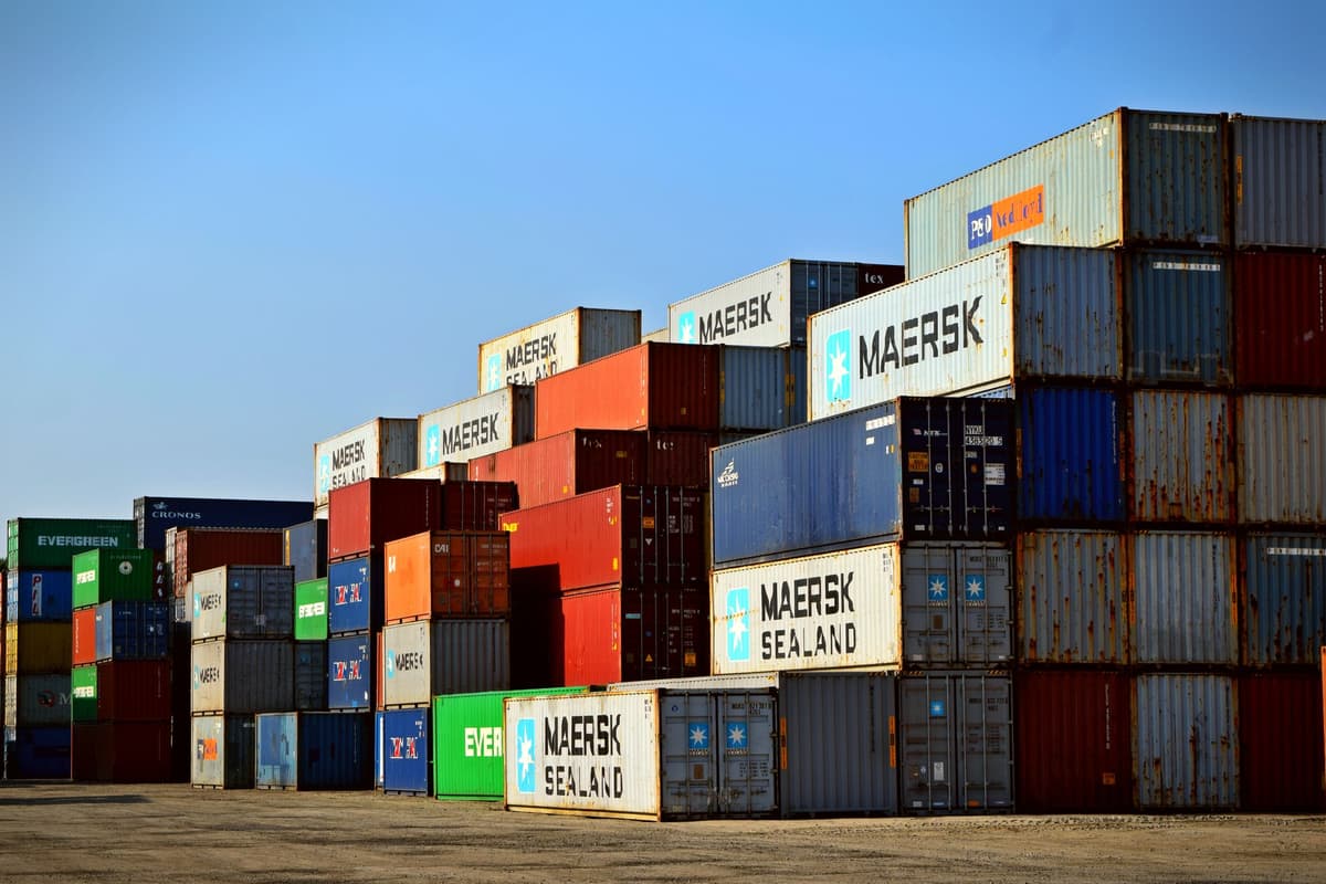 Stacked cargo shipping containers in a container yard: an illustrative image for freight and logistics networks.