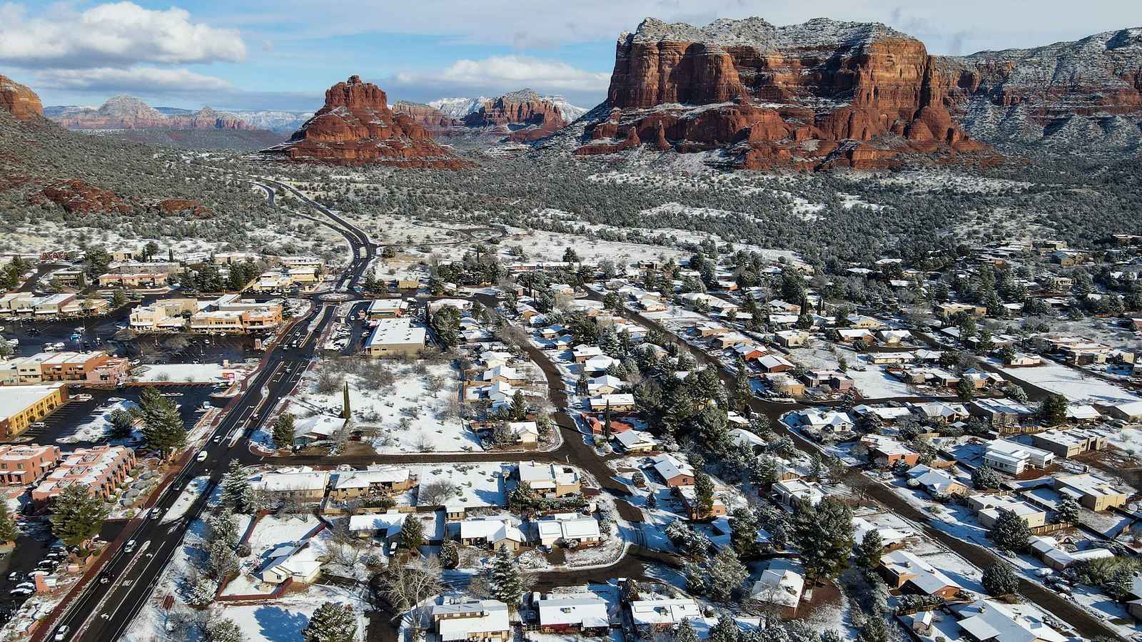Red rock buttes above a snow-dusted town at Sedona, Arizona: an illustrative image of the desert Southwest, not a photograph of this place.