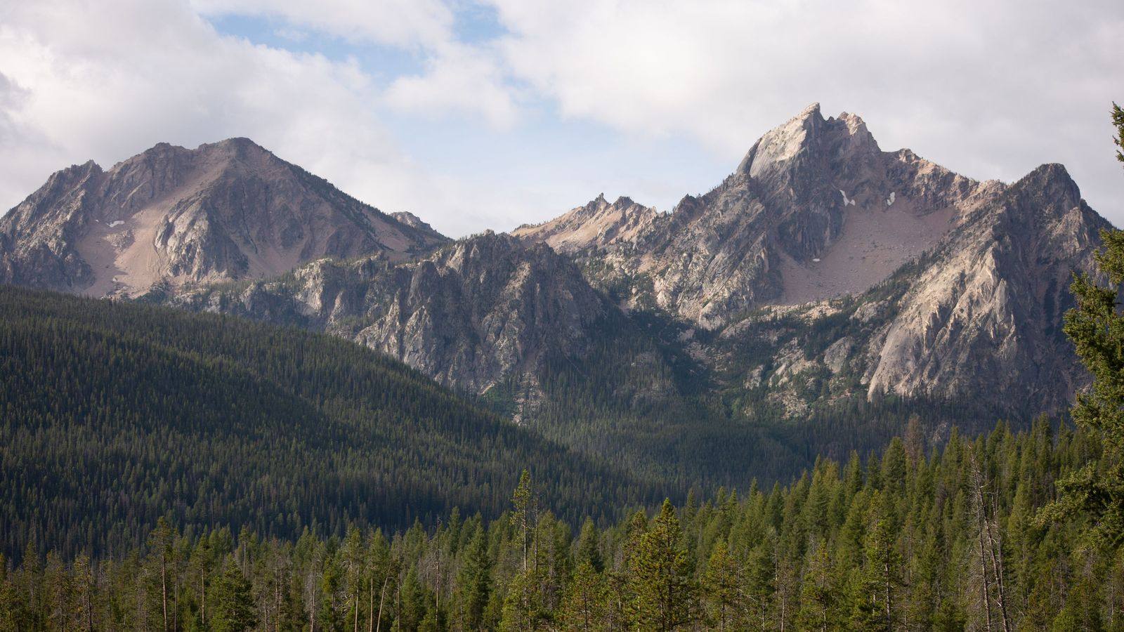 Jagged Sawtooth peaks above evergreen forest near Stanley, Idaho: an illustrative image of the state.